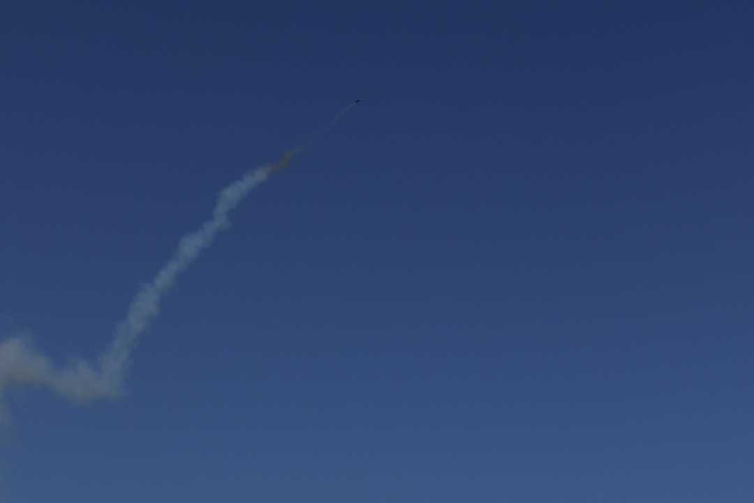 Model rocket smoke trail in a blue sky